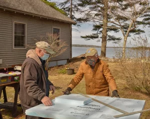 A pair of Home Repairs volunteers work on a project to help a Harpswell resident stay safe, warm and dry.