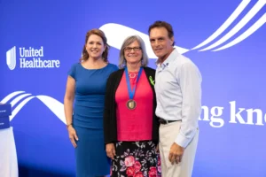 Gayle Hays (center) poses for a photo with Mary Snyder, CEO of UnitedHealthcare, New England, and Doug Flutie, former quarterback for the Boston College Eagles and the New England Patriots, during an event at Gillette Stadium in Foxborough, Massachusetts, on June 30.