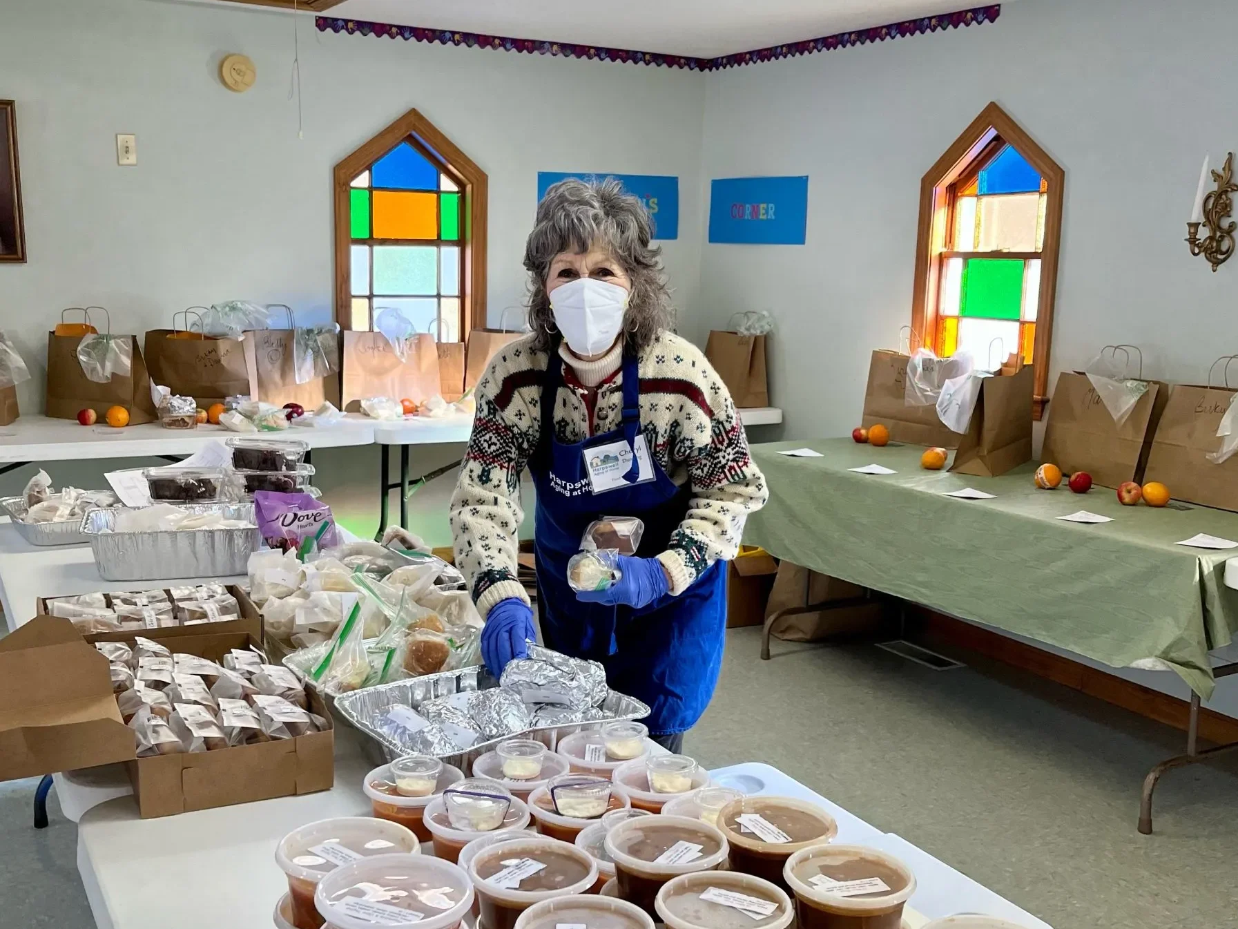 Harpswell Aging at Home volunteer Cheryl Dunning packs bags of food for delivery to Meals in a Pinch recipients.